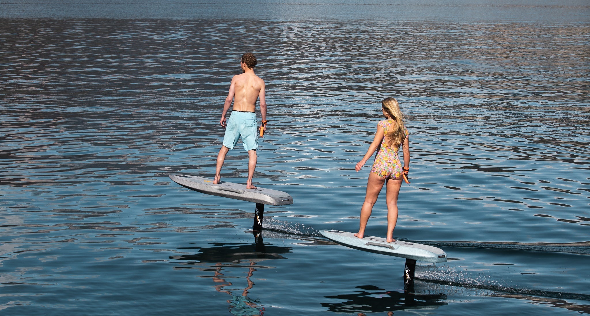 Man en vrouw aan het eFoilen op het water