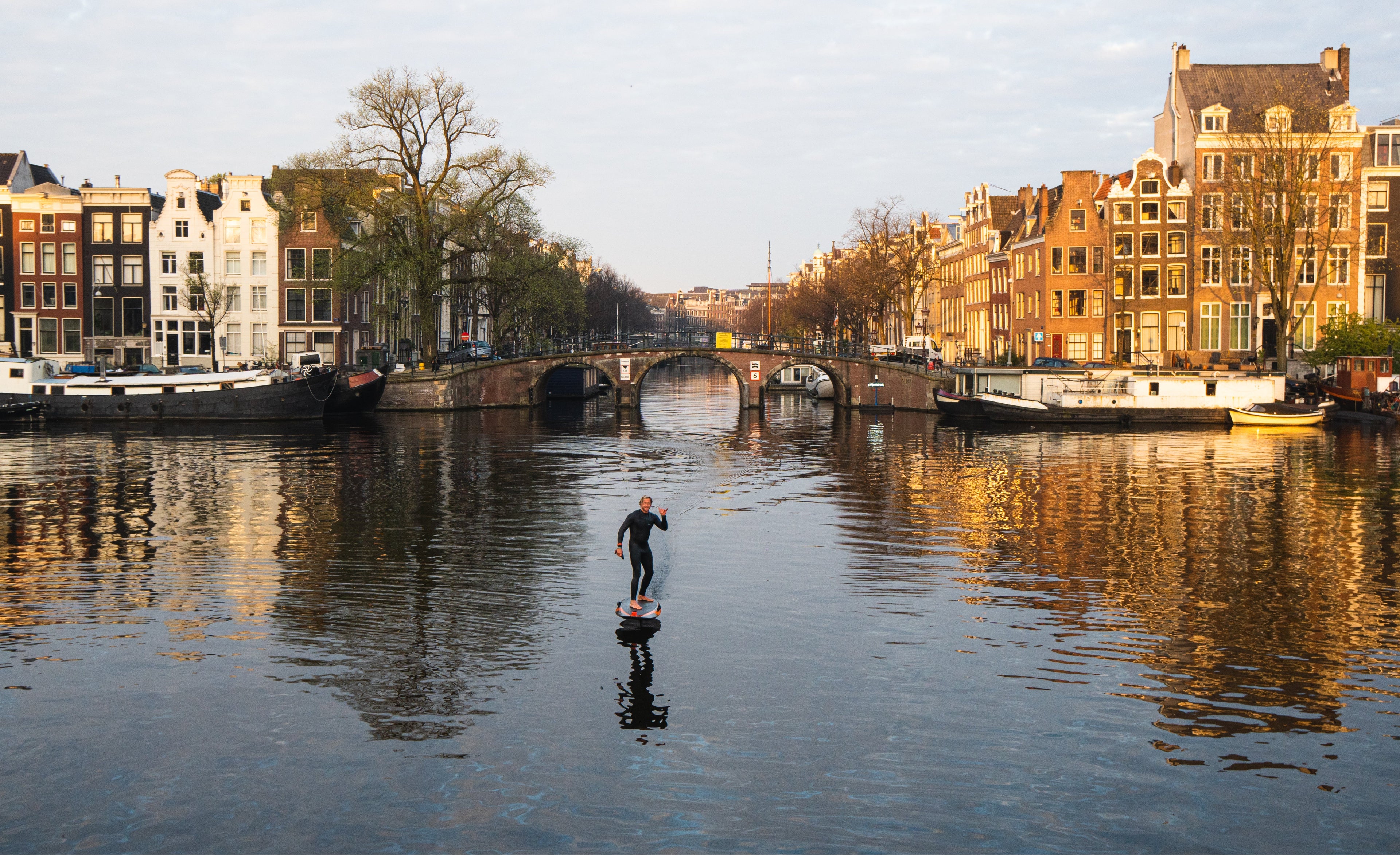 Man op het water aan het eFoilen in de grachten van Amsterdam