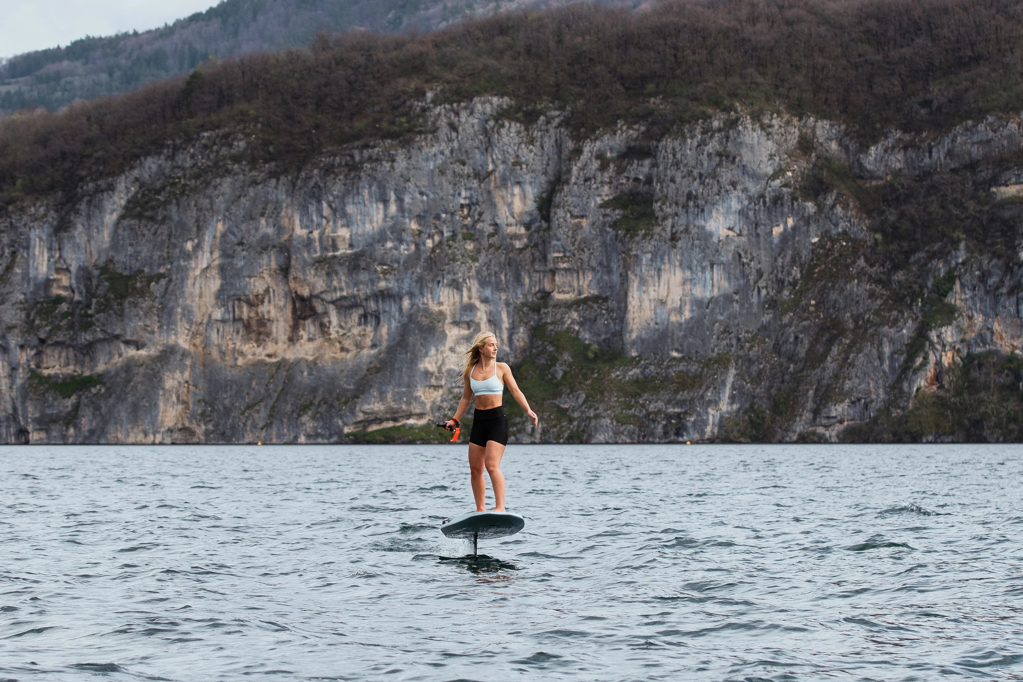 Vrouw aan het eFoilen op het water in bergachtig gebied