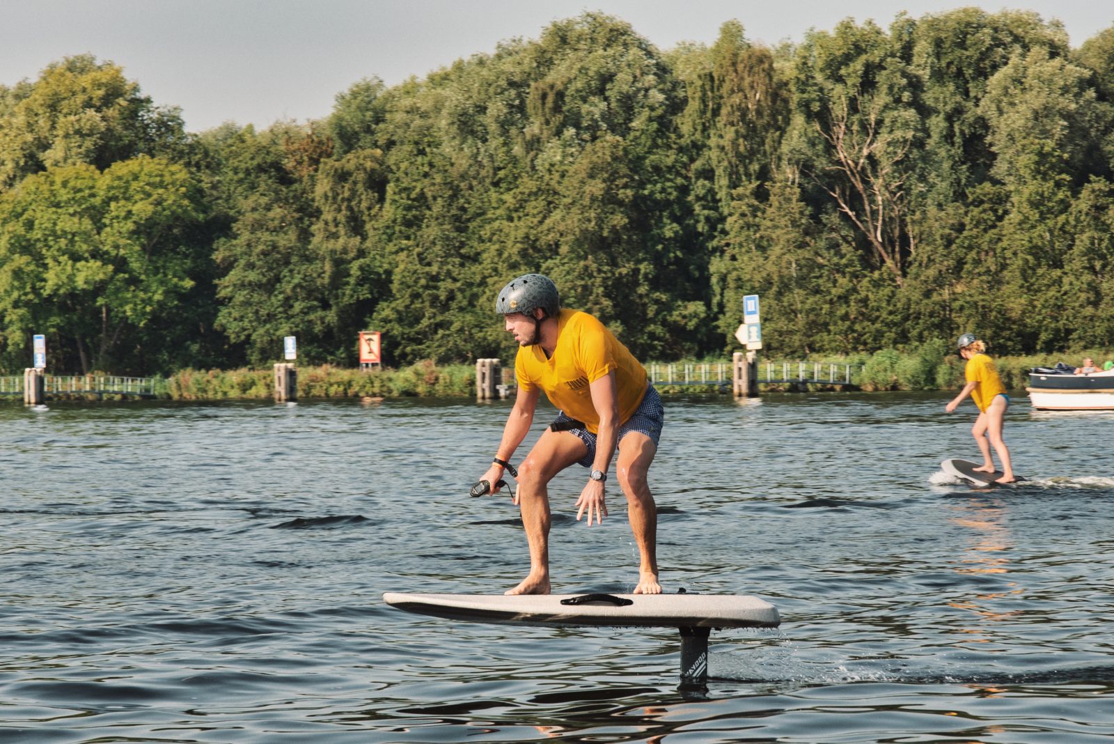 Twee personen aan het eFoilen tijdens een les op het water