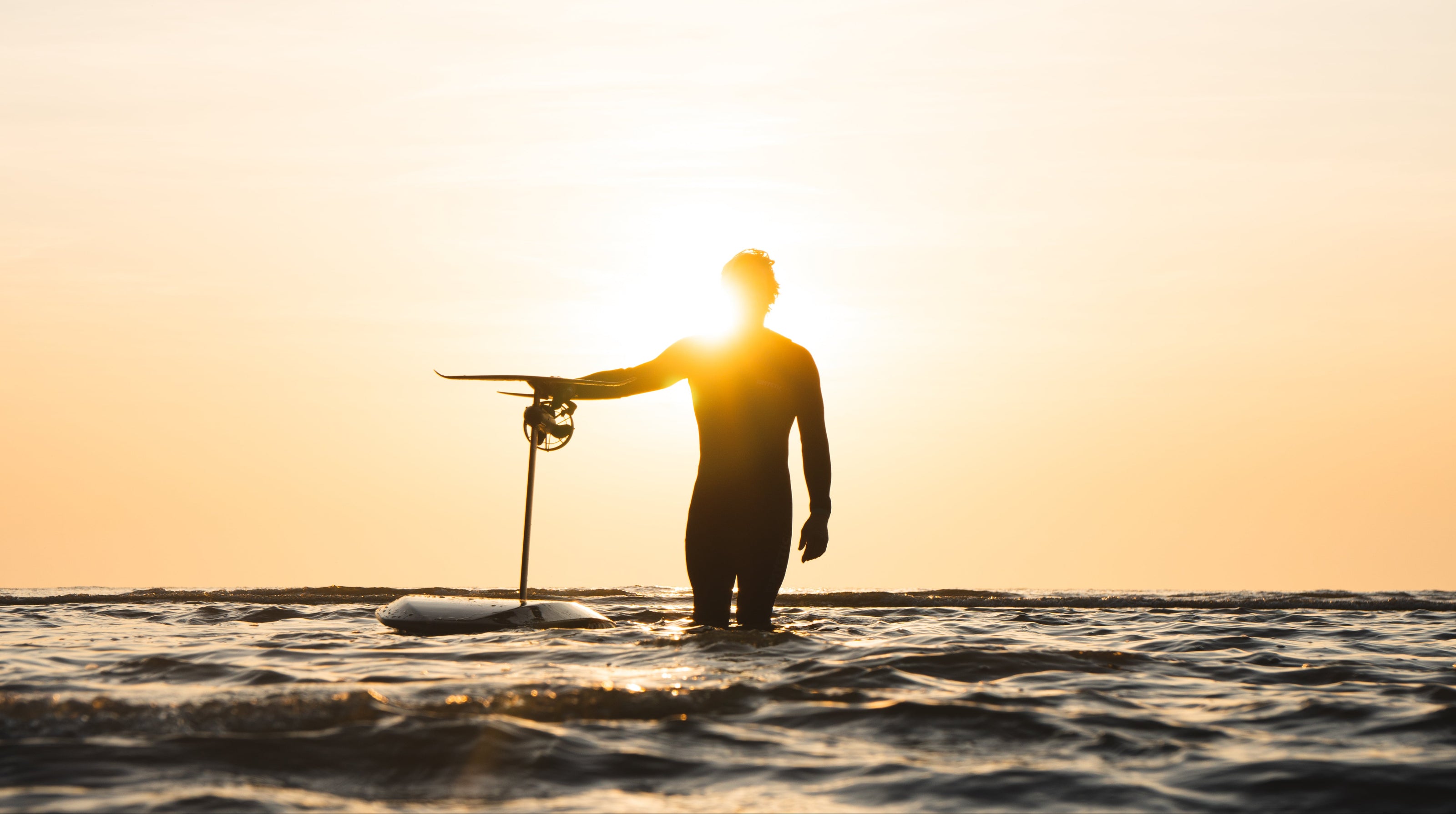 Man met eFoil in de zee tijdens zonsondergang